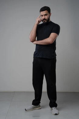 Problem solving and decision making, looking forward and planning for the future, portrait of a Saudi Arabian Gulf man in casual wear putting his hand on his head with gestures of thinking and absentmindedness, concept of scrutiny and concentration, full body, gray background