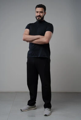  التقاط صور شخصية للوثائق الرسمية، الاعتناء والاهتمام بالمظهر الخارجي، مفهوم الاناقة والرجولة، بورتريه لشاب عربي خليجي سعودي يرتدي الزي الكاجوال يقف بأيدي متقاطعة ينظر الى الكاميرا بتعابير السرور والثقة بالنفس، الجسم بالطول الكامل، خلفية رمادية