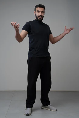 الشعور بالحيرة وعدم المعرفة، بورتريه لرجل عربي سعودي خليجيي يرتدي الزي الكاجوال يرفع يديه لأعلى بإيماءات عدم التأكد, التردد وعدم الثقة بخصوص أمر معين، الوقوف باستقامة والنظر إلى الكاميرا، صورة الجسم بالطول الكامل,خلفية رمادية