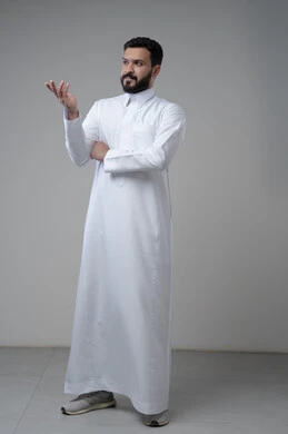 الشعور بالحيرة وعدم المعرفة، بورتريه لرجل عربي سعودي خليجيي يرتدي الثوب التقليجي يرفع يديه لأعلى بإيماءات عدم التأكد, التردد وعدم الثقة بخصوص أمر معين، الوقوف باستقامة والنظر إلى الكاميرا، صورة الجسم بالطول الكامل,خلفية رمادية