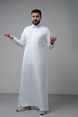 الشعور بالحيرة وعدم المعرفة، بورتريه لرجل عربي سعودي خليجيي يرتدي الثوب التقليجي يرفع يديه لأعلى بإيماءات عدم التأكد, التردد وعدم الثقة بخصوص أمر معين، الوقوف باستقامة والنظر إلى الكاميرا، صورة الجسم بالطول الكامل,خلفية رمادية