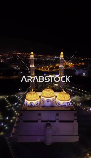 العبادة والتقرب الى الله، أداء الفرائض الدينية، الفن الهندسي المعماري الاسلامي الحديث لمساجد محافظة مسقط، أماكن ومعالم إسلامية دينية مقدسة مشهورة في سلطنة عمان، قبب ومآذن جامع محمد الأمين المضاءة في وقت الليل في ولاية بوشر