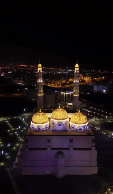 العبادة والتقرب الى الله، أداء الفرائض الدينية، الفن الهندسي المعماري الاسلامي الحديث لمساجد محافظة مسقط، أماكن ومعالم إسلامية دينية مقدسة مشهورة في سلطنة عمان، قبب ومآذن جامع محمد الأمين المضاءة في وقت الليل في ولاية بوشر
