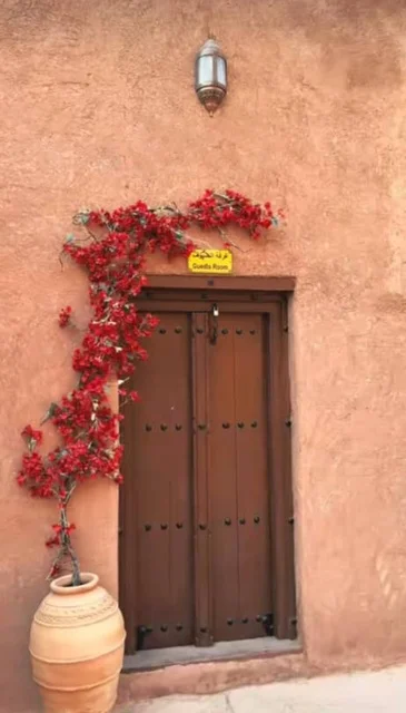 باب خشبي علة الطراز القديم لقلعة نخل المبنية من الطين في ولاية نخل في سلطنة عمان ,التصميم والفن الهندسي المعماري على الطراز القديم، معلم ومزار سياحي تراثي مشهور في محافظة جنوب الباطنة، حصن وبناء على الصخر، استخدام الاواني الفخارية.