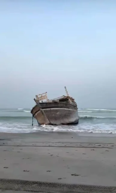 An old wooden boat on the shore of Masirah Island in the South Al Sharqiyah Governorate, the waterfront in the Sultanate of Oman during the day, enjoying the fun sea trips and tours, famous coastal tourist places