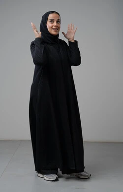 Gestures of boredom and headache, portrait of a veiled Saudi Arabian Gulf woman wearing a black abaya raising her hands with gestures of tension and nervousness, full body image, white background
