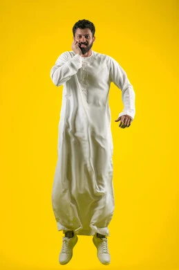 تسوس الأضراس وإلتهاب اللثه, الإحساس بوجع الأسنان والتألم من النخور، الحاجة للذهاب الى العيادة السنية، الشعور بالتعب والمرض, بورتريه لشاب عربي خليجي إماراتي يرتدي الكندورة يقفز عاليا ويضع يديه على خده بتعابير الألم, الجسم بالطول الكامل، خلفية صفراء