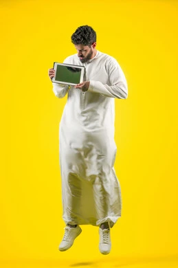 Using modern and advanced technology, completing work tasks remotely via a portable tablet, displaying a blank black screen via the tablet, portrait of an Arab Gulf Emirati man wearing a kandura, full body length, yellow background Using modern and advanced technology, completing work tasks remotely via a portable tablet, displaying a blank black screen via the tablet, portrait of an Arab Gulf Emirati man wearing a kandura, full body length, yellow background