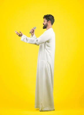 Gestures of happiness and integration with the song, artistic singing talents, recording a singing audio clip, side portrait of a young Arab Gulf Emirati man wearing a kandura singing using a microphone with enthusiastic expressions, full body image, yellow background