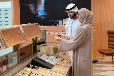 المتعة بالتسوق في مولات الإمارات، انواع وماركات عالميه ، مفهوم ضعف النظر، الاناقة والاهتمام بالمظهر الخارجي، اقتناء الاكسسورات من المولات ، مواكبة آخر صيحات الموضة والجمال، زوجان عربيان خليجيان اماراتيان يقومان باختيار نظارة طبية ملائمة لملامح الوجه