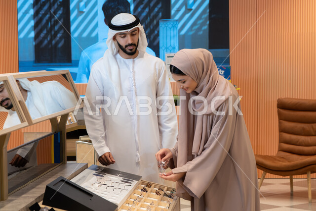انواع وماركات عالميه ، زوجان عربيان خليجيان اماراتيان يقومان باختيار نظارة طبية ملائمة لملامح الوجه، المتعة بالتسوق في مولات الإمارات،مفهوم ضعف النظر،الاناقة والاهتمام بالمظهر الخارجي، مواكبة آخر صيحات الموضة والجمال، اقتناء الاكسسورات من المولات