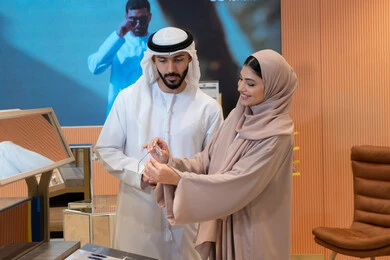 An Emirati Gulf Arab couple choosing eyeglasses that suit their facial features, enjoying shopping in the UAE malls, the concept of weak eyesight, elegance and interest in appearance, keeping up with the latest fashion and beauty trends, buying accessories from malls, global types and brands