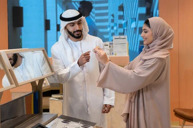 Enjoy shopping in the malls of the Emirates, an Arab Gulf Emirati couple choosing eyeglasses that suit their facial features, the concept of weak eyesight, elegance and interest in external appearance, keeping up with the latest fashion and beauty trends, buying accessories from the malls, types and international brands