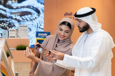 Keeping up with the latest fashion and beauty trends, taking care of one's appearance, an Emirati Gulf Arab couple choosing sunglasses that suit their facial features, protecting their eyes from the sun's rays, and enjoying shopping in the UAE malls.
