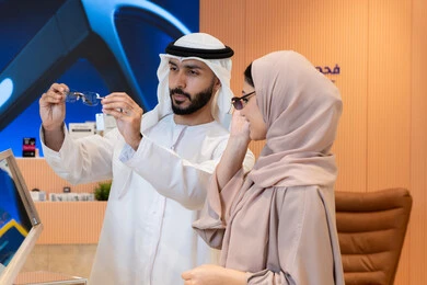 الاهتمام بالمظهر الخارجي،مواكبة آخر صيحات الموضة والجمال، حماية العينين من أشعة الشمس، المتعة بالتسوق في مولات الإمارات، زوجان عربيان خليجيان اماراتيان يقومان باختيار نظارة شمسية ملائمة لملامح الوجه