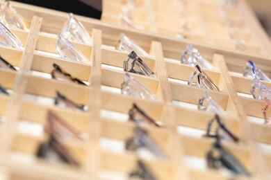 الحيرة في اختيار نظارة مناسبة، الركن الخاص بالنظارات الطبية ، فحص النظارات الطبيه قبل الشراء، متعة التسويق والشراء ، صورة مقربة ليد امراه عربية خليجية اماراتية ترتدي العباءه تقوم باختيار نظاره طبيه