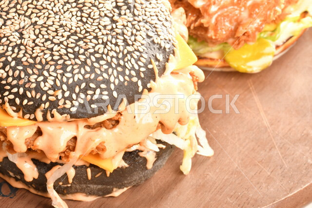 Delicious burger sandwich with layers of fresh meat and melted cheese with tomatoes and lettuce, Arabic food, delicious food recipes, fast food