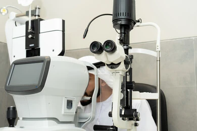 Diagnosis and identification of visual problems, ensuring the health of vision, assessing the range of vision and detecting eye diseases, the concept of services and healthcare in hospitals and medical centers, an Arab Gulf Emirati man examining his eyes with an ophthalmoscope, using modern advanced devices.