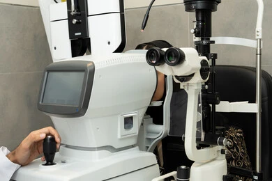 A Saudi woman is checking her vision health, assessing visual acuity and detecting eye diseases, diagnosing and identifying visual problems, using advanced modern devices. An Arab Gulf Emirati woman is examining her eyes with an ophthalmoscope, the concept of healthcare services and medical care in hospitals and medical centers.
