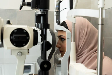 تشخيص وتحديد المشاكل البصرية، استخدام الأجهزة الحديثة المتطورة، امراه عربيه خليجيه اماراتيه تقوم بفحص عينيها بجهاز المنظار العيني، تقييم مدى الرؤية والكشف عن الامراض العينية، مفهوم الخدمات والرعاية الصحية في المشافي والمراكز الطبية ، سيدة سعودية تتأكد من صحة البصر