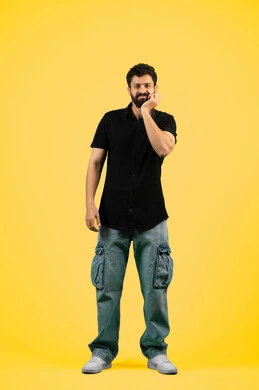 تسوس الأضراس وإلتهاب اللثه, الإحساس بوجع الأسنان والتألم من النخور، الحاجة للذهاب الى العيادة السنية لوضع الخطة العلاجية، الشعور بالتعب والمرض, بورتريه لشاب عربي خليجي إماراتي يرتدي الزي الكاجوال يضع يديه على خده بتعابير الألم, الجسم بالطول الكامل، خلفية صفراء