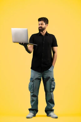 The concept of diligence and completion of required tasks, browsing social networking sites, watching movies and series, portrait of a young Saudi Arabian Gulf man wearing casual clothes holding a laptop in his hand, an Emirati man looking at a computer, full body, yellow background