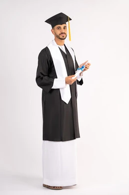 إنهاء المرحلة الجامعية، تعابير السرور والسعادة بالنجاح، التقاط صور شخصية بثياب التخرج، بورتريه لشاب خريج عربي خليجي اماراتي مبتسم يرتدي القبعة وعباءة التخرج يحمل الشهادة ينظر الى الكاميرا بإيماءات البهجة، الجسم بالطول الكامل، خلفية بيضاء