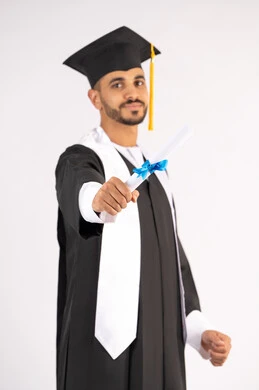 الشعور بالفخر والثقة بالنفس، الاحتفال بالنجاح وانهاء الدراسة الجامعية، مفهوم التفوق والاجتهاد، بورتريه لخريج عربي خليجي اماراتي يرتدي قبعة وثوب التخرج يقف باستقامة بايماءات السعادة،  حمل الشهادة بتعابير الفروح والسرور، خلفية بيضاء