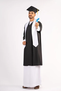 Achieving the dream of success, expressions of happiness and pleasure, university occasion and celebration, celebration of completing university studies, concept of diligence and excellence, portrait of a smiling young Arab Gulf Emirati graduate wearing a graduation gown holding a certificate in his hand, full body, white background