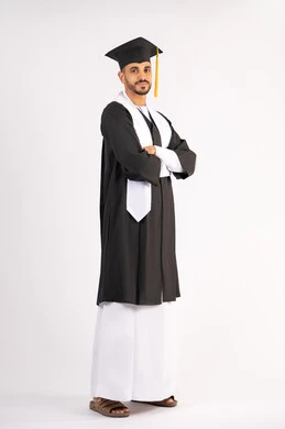النجاح والاجتهاد والتفوق، التقاط صور شخصية بثياب التخرج، الاحتفال بإنهاء المرحلة الجامعية، بورتريه لشاب خريج عربي خليجي اماراتي مبتسم يرتدي القبعة وعباءة التخرج يقف بأيدي متقاطعة ينظر الى الكاميرا بتعابير الثقة بالنفس، الجسم بالطول الكامل، خلفية بيضاء
