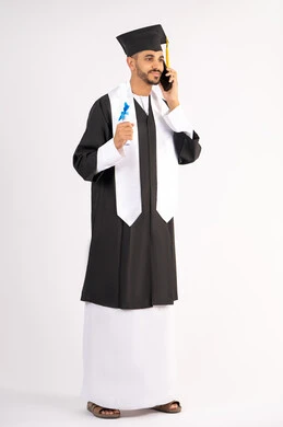 Communication with family and friends, the concept of diligence and excellence, celebrating the completion of university studies, the use of modern technology, a portrait of a young Arab Gulf Emirati graduate wearing an abaya and graduation cap making a call on a mobile phone, full body, white background