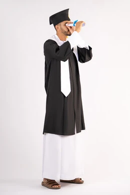 الفرح والفخر بالوصول لحلم النجاح، بورتريه لشاب خريج عربي سعودي خليجي يرتدي ثياب التخرج ينظر من خلال شهادة التفوق، الاحتفال بانتهاء المرحلة الجامعية، التطلع إلى المستقبل بعد التخرج، الجسم بالطول الكامل، خلفية بيضاء