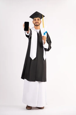 تطبيقات التعليم والدراسة اونلاين، عرض شاشة سوداء فارغة على الهاتف المحمول، بورتريه لشاب خريج عربي خليجي اماراتي مبتسم يرتدي القبعة وزي التخرج يمسك بيده الشهادة بتعابير السرور، الاحتفال بانتهاء المرحلة الجامعية، الجسم بالطول الكامل، خلفية بيضاء
