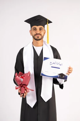 استلام الشهادة بتعابير الفرح، الشعور بالفخر والثقة بالنفس، الاحتفال بالنجاح وانهاء الدراسة الجامعية، مفهوم التفوق والاجتهاد، بورتريه لشاب خريج عربي خليجي اماراتي يرتدي قبعة وثوب التخرج يمسك بيده باقة الورد بايماءات السعادة، خلفية بيضاء