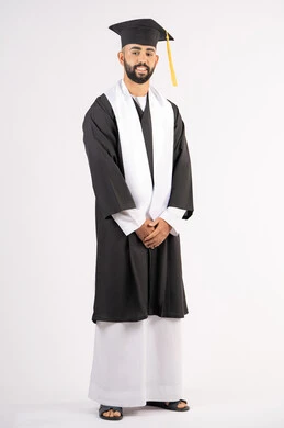 Hard work, diligence and success, taking selfies in graduation gowns, celebrating the completion of university, portrait of a smiling young Arab Gulf Emirati graduate wearing a graduation cap and gown, standing straight, looking at the camera with an expression of self-confidence, pleasure and happiness, full body, white background