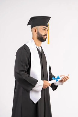 Holding a certificate with expressions of joy and happiness, feeling proud and self-confident, celebrating success and completing university studies, the concept of excellence and diligence, a portrait of an Arab Gulf Emirati graduate wearing a graduation cap and gown, standing straight with gestures of happiness, white background