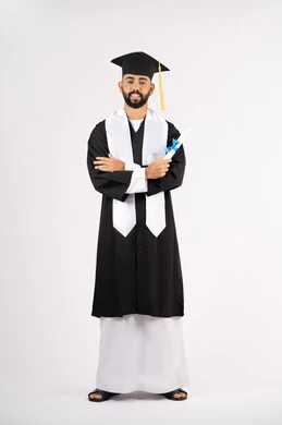 مفهوم التفوق والنجاح والاجتهاد، التقاط صور شخصية بثياب التخرج، الاحتفال بإنهاء المرحلة الجامعية، بورتريه لشاب خريج عربي خليجي اماراتي مبتسم يرتدي القبعة وعباءة التخرج يقف بأيدي متقاطعة ينظر الى الكاميرا بتعابير الثقة بالنفس، الجسم بالطول الكامل، خلفية بيضاء