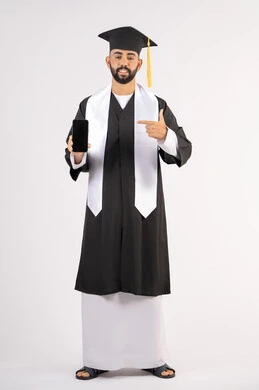 عرض شاشة سوداء فارغة على الهاتف المحمول، تطبيقات التعليم والدراسة اونلاين، بورتريه لشاب خريج عربي خليجي اماراتي مبتسم يرتدي القبعة وزي التخرج بتعابير السرور، الاحتفال بانتهاء المرحلة الجامعية، الجسم بالطول الكامل، خلفية بيضاء