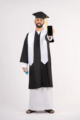 تطبيقات التعليم والدراسة اونلاين، عرض شاشة سوداء فارغة على الهاتف المحمول، بورتريه لشاب خريج عربي خليجي اماراتي مبتسم يرتدي القبعة وزي التخرج يمسك بيده الشهادة بتعابير السرور، الاحتفال بانتهاء المرحلة الجامعية، الجسم بالطول الكامل، خلفية بيضاء