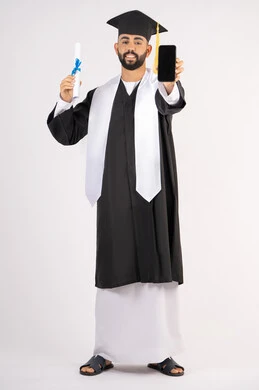 Online education and study applications, displaying a blank black screen on a mobile phone, a portrait of a smiling young Arab Gulf Emirati graduate wearing a cap and graduation gown, holding a certificate with an expression of joy, celebrating the end of the university stage, full body, white background