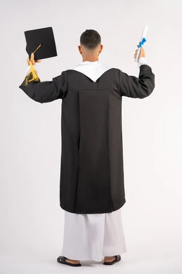 جودة الدراسة في الامارات العربية المتحدة، الشعور بالفخر والفرح بالوصول لحلم التخرج, الحصول على الشهادة، بورتريه من الخلف لشاب خريج عربي خليجي اماراتي يرتدي عباءة يرفع قبعة التخرج ووثيقة التخرج، الاحتفال بإنهاء المرحلة الجامعية، الجسم بالطول الكامل، خلفية بيضاء