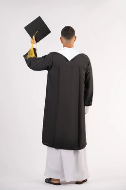 Education in the United Arab Emirates, feeling proud and happy to achieve the dream of graduation, portrait from the back of a young Arab Gulf Emirati graduate wearing an abaya raising a graduation cap, celebrating the completion of university, full body, white background