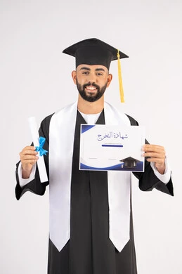 Quality of education in the UAE, achieving the dream of success, expressions of happiness and joy, the occasion of success at university, celebrating the completion of university studies, the concept of diligence and excellence, a portrait of a smiling young Arab Gulf Emirati graduate wearing a graduation gown and holding a certificate, white background