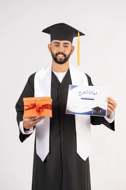 الحصول على وثيقة التخرج، تقديم الهدايا في المناسبات، الاحتفال بإنهاء الدراسة الجامعية، إيماءات السعادة بالوصول لحلم النجاح، بورتريه لشاب خريج عربي خليجي اماراتي يرتدي زي التخرج والقبعة يحمل بيده الشهادة وصندوق الهدية، خلفية بيضاء