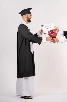 مفهوم التفوق والاجتهاد، استلام الشهادة بتعابير الفروح والسرور، بورتريه من الجانب لخريج عربي خليجي اماراتي يرتدي قبعة وثوب التخرج يقوم بأخذ باقة الورد بايماءات السعادة والسرور، الاحتفال بالنجاح وانهاء الدراسة الجامعية، صورة الجسم بالطول الكامل، خلفية بيضاء