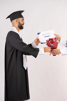 Celebrating success and completing university studies, feeling proud and self-confident, receiving the certificate with expressions of joy and happiness, the concept of excellence and diligence, a side portrait of an Arab Gulf Emirati graduate wearing a graduation cap and gown taking a bouquet of flowers with gestures of happiness, white background