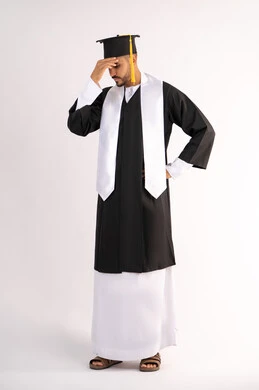 Waiting impatiently for results, exhaustion and fatigue after hard work and perseverance, finishing university studies after suffering, portrait of a young Arab Gulf Emirati graduate wearing a cap and graduation gown, putting his hand on his head with an expression of despair, full body, white background