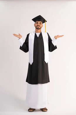The concept of excellence and success, taking selfies in graduation gowns, celebrating the completion of university, portrait of a smiling young Arab Gulf Emirati graduate wearing a graduation cap and gown, raising his hands up, looking at the camera with an expression of pleasure, full body, white background
