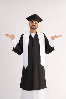 The concept of excellence and success, taking selfies in graduation gowns, celebrating the completion of university, portrait of a smiling young Arab Gulf Emirati graduate wearing a graduation cap and gown, raising his hands up and looking at the camera with an expression of pleasure, white background