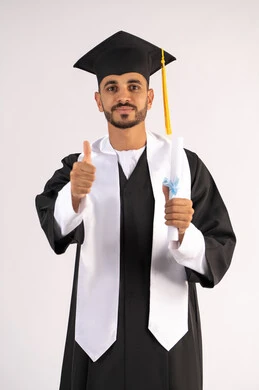 Occasion and joy of success, raising the thumb up with an expression of admiration, taking selfies in graduation clothes, celebrating the completion of the university stage, portrait of a young Arab Gulf Emirati graduate wearing a graduation cap and gown, holding a certificate, looking at the camera with gestures of pleasure, white background